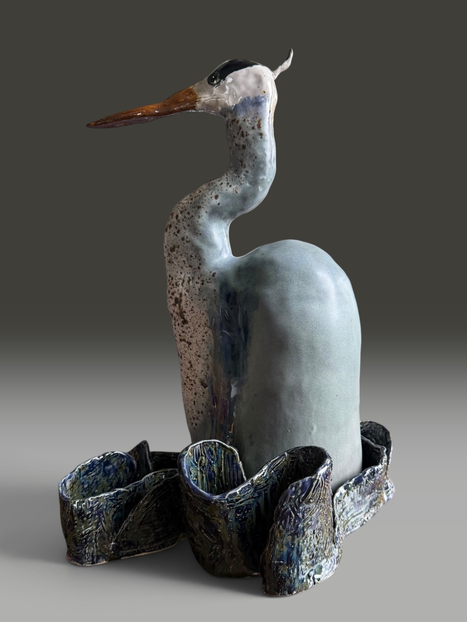 Soft Landing, a heron with a speckled neck rising from a ruffled base